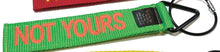 Load image into Gallery viewer, Green luggage tag with red embroidered text: NOT YOURS