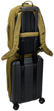 Load image into Gallery viewer, Angled back panel view of the backpack's attachment strap holding on to the telescopic handle of a suitcase.
