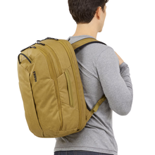 Load image into Gallery viewer, A young man carrying the nutria brown backpack on his back.