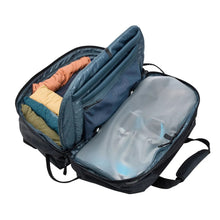 Load image into Gallery viewer, Interior view of the black duffle bag filled with clothes and travel accessories.