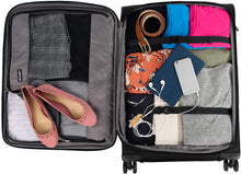 Load image into Gallery viewer, Interior view of the black suitcase filled with clothes and accessories. The main compartment has a set of adjustable straps holding the contents.