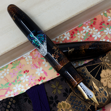 Load image into Gallery viewer, The fountain pen resting on the cap and kimono sleeve.