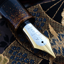 Load image into Gallery viewer, Close up to the bi-colored engraved nib. It features the Taccia logo, 18K, 750, JAPAN.