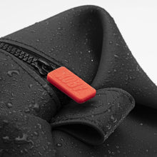 Load image into Gallery viewer, Close up to the red zipper tag on the toiletry bag. It features the word KOBY on it.