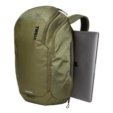 Load image into Gallery viewer, Angled side panel view of the Olivine Green backpack with a laptop peeking from the back compartment.