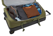 Load image into Gallery viewer, Interior view of the main compartment with folded clothes and a pair of shoes arranged