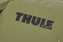 Load image into Gallery viewer, Close up to the Thule log on the front panel. There are water droplets on the fabric, featuring the waterproof material.