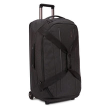 Load image into Gallery viewer, Angled front panel view of the wheeled duffle bag with the grab handles clasped together with a velcro strap.