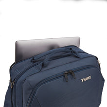 Load image into Gallery viewer, Angled view of the blue bag with a laptop peeking from the back panel's compartment.