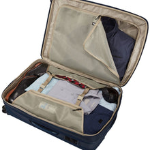 Load image into Gallery viewer, Angled interior view of the suitcase with a set of folded clothes and toiletries tucked in the compartments.