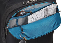 Load image into Gallery viewer, Close up to the front pocket shown unzipped. A wallet, a set of keys and a boarding pass are tucked inside.