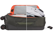 Load image into Gallery viewer, Side panel view of the suitcase showing the front panel unzipped, and the main compartment  shown filled with clothes.