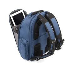 Load image into Gallery viewer, Angled back panel view of the blue backpack with the front pocket unzipped. A tablet is placed inside.
