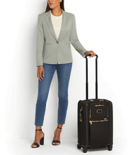 Load image into Gallery viewer, A young woman holding the suitcase by the extended telescopic handle.
