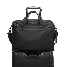 Load image into Gallery viewer, The black briefcase shown with the attachment feature holding it onto a suitcase.