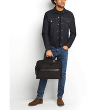 Load image into Gallery viewer, A young man holding the black briefcase by the grab handles.