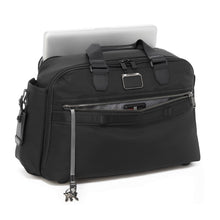 Load image into Gallery viewer, Angled front panel view of the black duffel with the front pocket unzipped. It has a key lanyard attached to the inside, and a laptop compartment.