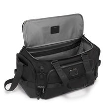 Load image into Gallery viewer, Angled front panel view of the black duffel with the top lid's main compartment unzipped.