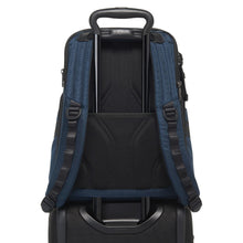 Load image into Gallery viewer, Back panel view of the Navy Blue backpack with a suitcase's telescopic handle slid through the back strap, holding it in place.