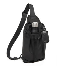 Load image into Gallery viewer, Front panel view of the black sling bag with water bottle inside a compartment. (Water bottle not included).