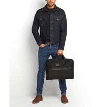 Load image into Gallery viewer, A young man holding the black briefcase by the handle straps.