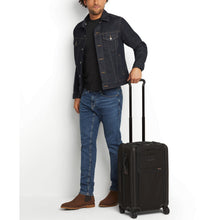 Load image into Gallery viewer, A young man holding the black suitcase by the extended telescopic handle.