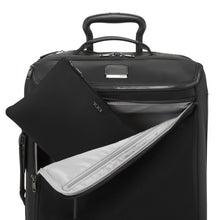 Load image into Gallery viewer, The tote bag in its folded position being stored inside a suitcase's front pocket.