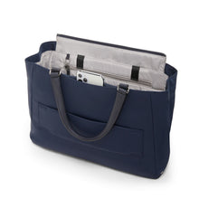 Load image into Gallery viewer, Angled back panel view of the bag showing a phone inside the pocket under the grab handle.