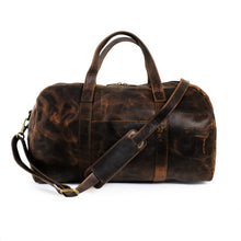 Load image into Gallery viewer, Front view of the brown distressed leather duffle bag. The shoulder strap is attached and resting across the front.