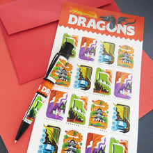 Load image into Gallery viewer, Side view of the dragons pen arranged with red envelopes and a card with cartoon dragons on stamp designs.
