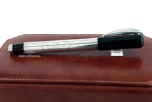 Load image into Gallery viewer, Side view of the fountain pen with the cap on, close. Placed on top of the brown leather presentation box.