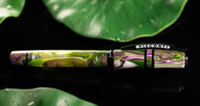 Load image into Gallery viewer, Side view of the Visconti Homo Sapiens Lotus Garden Fountain pen with the cap on. The background is black and has lily pads.