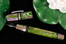 Load image into Gallery viewer, The Visconti Homo Sapiens Lotus Garden Fountain pen with the cap set next to it. The background has Lily pads and a white lotus flower.