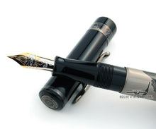 Load image into Gallery viewer, Close up to the nib and grip secction resting on the cap.