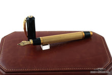 Load image into Gallery viewer, The fountain pen with the cap set behind it. Placed on top of the leather presentation box.