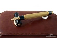 Load image into Gallery viewer, The fountain pen with the nib resting on top of the cap. Placed on top of the leather presentation box.