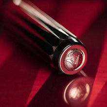 Load image into Gallery viewer, Angled view of the cap top on a red background.