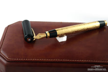 Load image into Gallery viewer, The fountain pen with the cap set next to it. Both are placed on top of the leather presentation box.