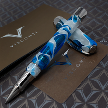 Load image into Gallery viewer, Visconti Opera Master Antartica Rollerball Pen resting on the cap. They are placed on top of the presentation box with the certificates.
