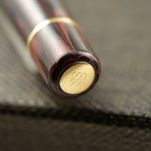 Load image into Gallery viewer, Close up to the edition number engraved at the bottom of the pen with gold vermeil trims. It reads 003/300.