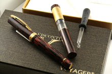 Load image into Gallery viewer, The brown fountain pen arranged with the presentation box, portable ink tube, and eye dropper on top of the presentation boxes.