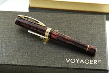 Load image into Gallery viewer, Side view of the fountain pen with gold vermeil trims. Set on top of the presentation box lid.