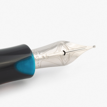 Load image into Gallery viewer, Close up to the Visconti Woodstock Dark Lava Lamp Fountain Pen nib. It is engraved with a set of decorations, 134K, M, and the word VISCONTI.