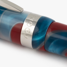 Load image into Gallery viewer, Close up to the cap ring of the Visconti Woodstock Lava Lamp Fountain Pen. The engraved O's in the word WOODSTOCK are in the shape of peace symbols.