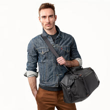 Load image into Gallery viewer, Briggs & Riley ZDX Cargo Crossbody Satchel - Black
Image of Satchel carried in crossbody position by male model
	Height	Width	Depth	Weight
US	13.25"	22.25"	12"	          2.1 lbs.
EU	33.8 cm	30.5 cm	56.6 cm	 .9 kg