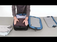 Load and play video in Gallery viewer, A young man packs a set of clothes inside the suitcase's main compartment, and uses the included panel divider to hold them in place.