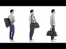 Load and play video in Gallery viewer, Review of the  black duffle bag showing its spacious interior and organization pockets and panels filled with clothes, a pair of shoes, electronics, a water bottle, and other accessories. A shoulder strap is available to carry it hands free.