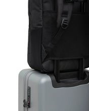 Load image into Gallery viewer, Angled back panel view of a black Kaslo backpack attached to the telescopic handle of a suitcase.
