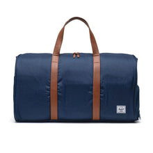 Load image into Gallery viewer, A navy blue Herschel Novel Duffle duffle bag with brown leather handles and a logo on the front.
