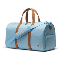 Load image into Gallery viewer, Angled front view of the bluebell crosshatch duffle bag with tan grab handles. The matching blue adjustable shoulder strap is laid across the front.
